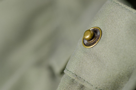 Green military cloth macro fittings clothing on blur backgroundの写真素材