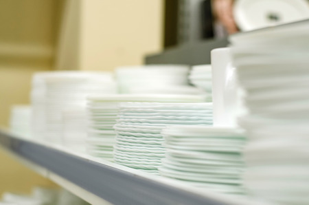 Many plates on the shelf of the store white set cookingの写真素材
