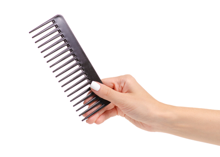 Black hair comb in hand on white background isolationの写真素材