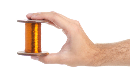 Copper wire power in hand isolated on a white background.の写真素材