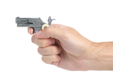 Metal toy gun in hand on white background isolation