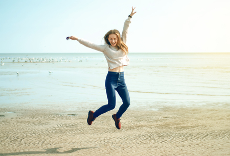 Happy woman jumping on the beachの写真素材
