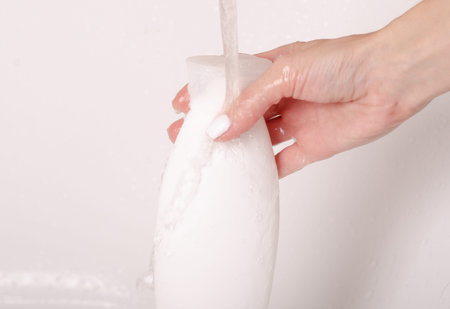 White bottle gel shower in hands water bath cosmetic care bodyの写真素材