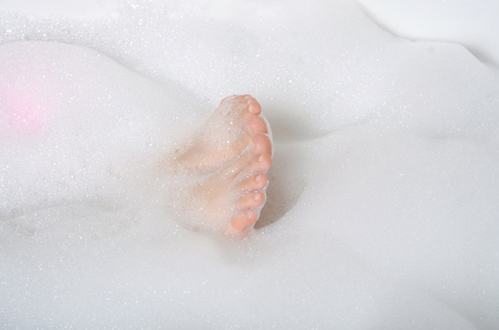 Beautiful woman in bath foam beauty health legs fingers care body waterの写真素材