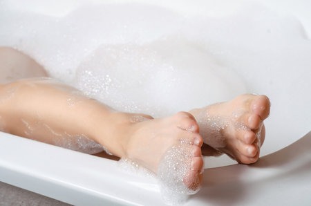 Beautiful woman in bath foam beauty health legs care body water