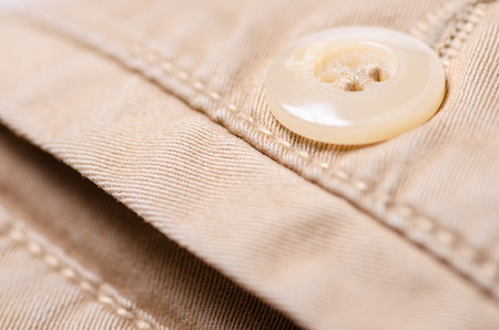 Brown jeans fabric textile material texture button macro blur backgroundの写真素材