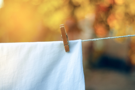 White T-shirt hanging on a clothespin nature on blur backgroundの写真素材