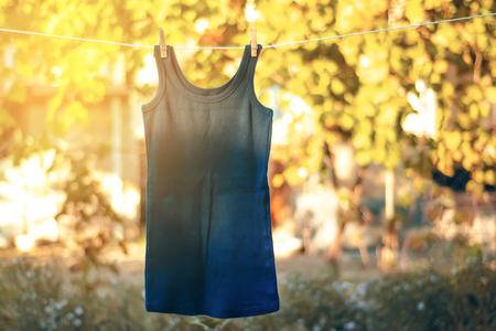 Blue shirt hanging on a clothespin nature on blur backgroundの写真素材