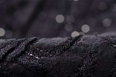Black fabric texture material sparkles sequins shine on blur backgroundの写真素材