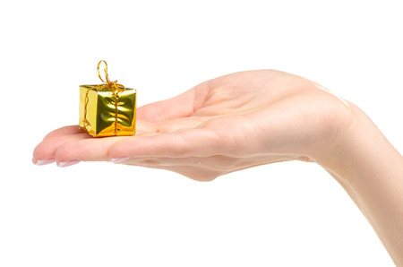Christmas toys golden gifts box in hand isolated on a white background.の写真素材