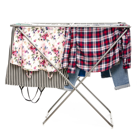 The clothes drying rack with clean clothes isolated on white background.の写真素材