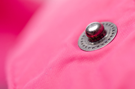 Pink fabric material textile clothes fittings button clasp macro on blur backgroundの写真素材
