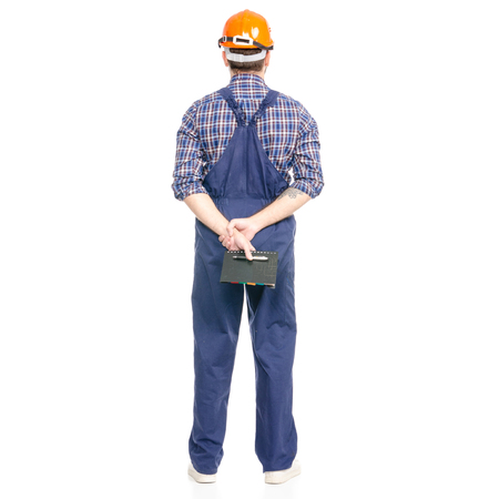 Young man builder industry worker hardhat with a notebook and pen in hand isolated on a white background.の写真素材