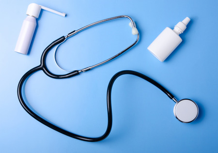 Medical Concept. Top view of stethoscope, medication, sray nose throat on blue background. Flat lay and copy spaceの写真素材