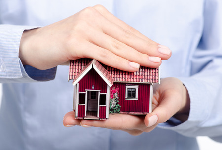 Hands holding Family small house model isolated on white background, protect houseの写真素材