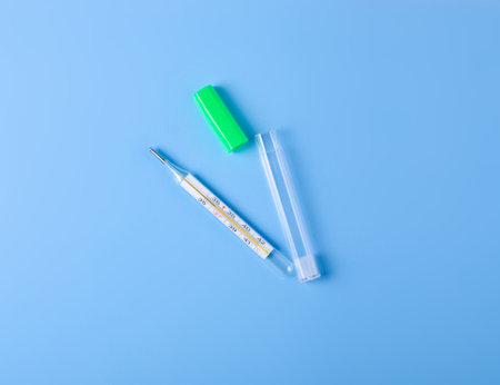 thermometer on blue background, top view, medical pharmacy concept