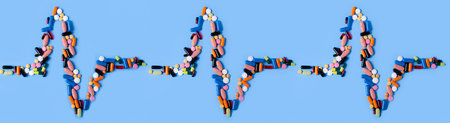 Pills capsules heart pulse medicine health on blue background top view, medical pharmacy concept