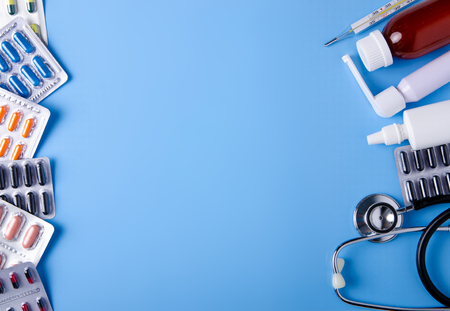 Pills capsules thermometer stethoscope nose throat spray cough syrup medicine health on blue background top view, medical pharmacy conceptの写真素材