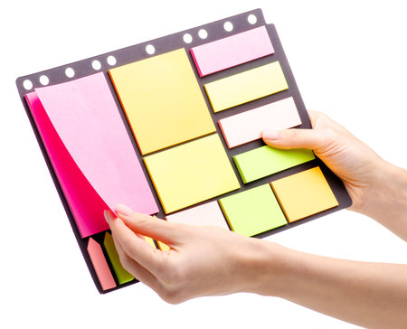 Colorful notes paper in hand isolated on white background.