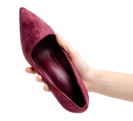 Female red suede high heels shoes in hand isolated on white background.の写真素材