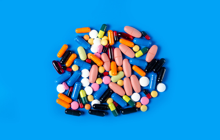Colorful pills medical on blue background top view, pharmacy conceptの写真素材