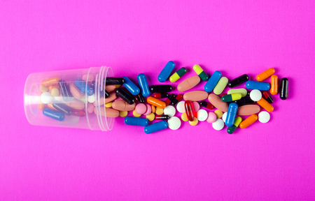 Colorful pills medical on pink background top view, pharmacy conceptの写真素材