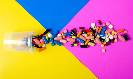 Colorful pills medical on color background top view, pharmacy conceptの写真素材