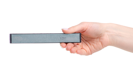 Whetstone knife in hand isolated on white background.の写真素材