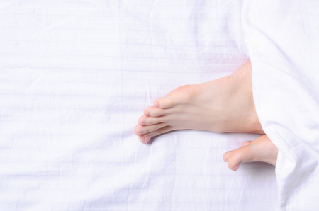 Female's legs beauty on white bed beauty heels of the foot, top viewの写真素材