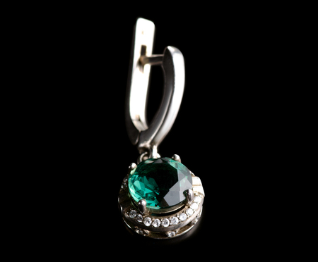Jewelry silver earrings with green stone isolated on a black background.の写真素材