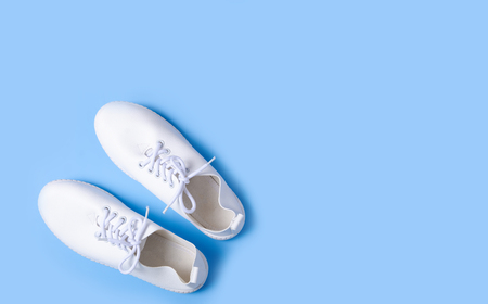 Pair of white sneakers on color background, flat lay, top viewの写真素材