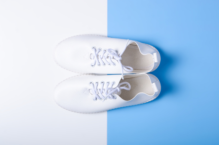 Pair of white sneakers and space for text on color background, flat lay, top viewの写真素材