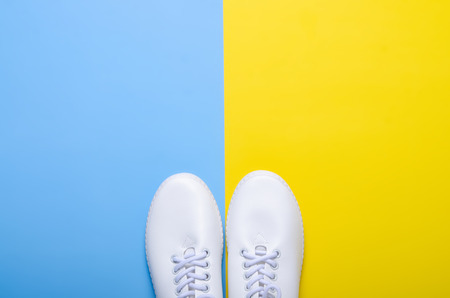 Pair of white sneakers on color background, flat lay, top viewの写真素材
