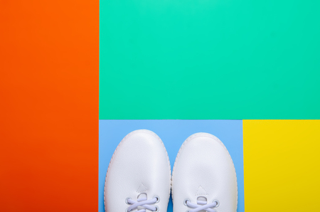 Pair of white sneakers on color background, flat lay, top viewの写真素材