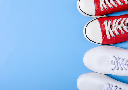 Two pairs of sneakers and space for text on color blue background, flat lay, top viewの写真素材
