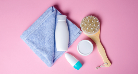 White towel, jar cream, lotion, roller deodorant, massage brush soft beauty on pink background, top viewの写真素材