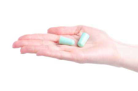 Green ear plugs in hand