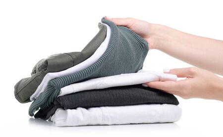 Stack folded green white clothing in handの写真素材