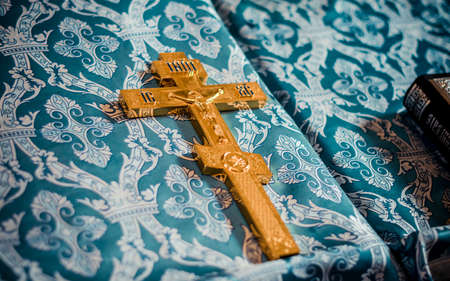 Big golden cross on blue clothの写真素材