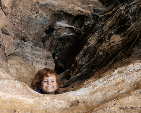 6 year old kid look out from caveの写真素材
