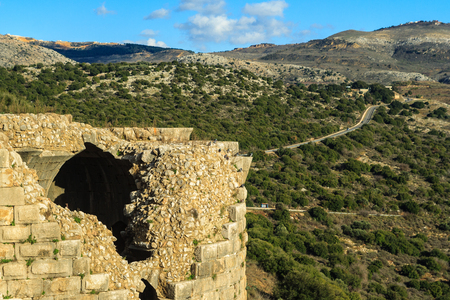 Ruins of ancient Crusader fortress, Golan Heights background, beautiful sky with white clouds and sunlight rays, Upper Galilee, Israel. Concept: travel, history and natureの写真素材
