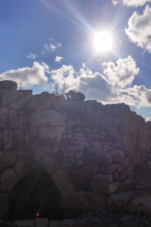 Silhouette of man with camera on the ruins of an ancient castle, taking pictures of landscapes. Against the sun, strong glare and rays.の写真素材