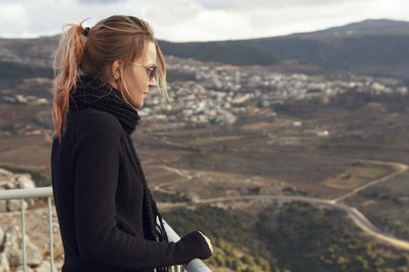 A young woman looks sadly at the mountain range. Israelの写真素材