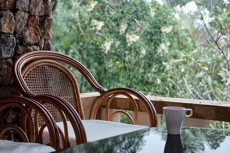 Wicker chair on balcony, cup of coffee and book. Concept calmness, meditation, old age, downshifting. Thailandの写真素材