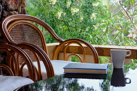 Wicker chair on balcony, cup of coffee and book. Concept calmness, meditation, old age, downshifting. Thailandの写真素材