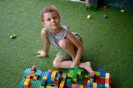 Cute handsome smiling boy playing with plastic construction toys. Amusement playground. Thailandの写真素材