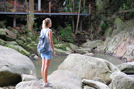 Young woman stands near waterfall, Thailand. Concept: discoveryの写真素材