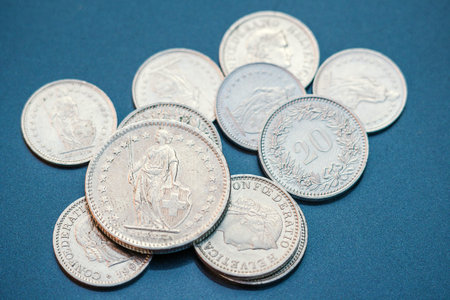 Swiss money, a steel coin, lies on a blue background.