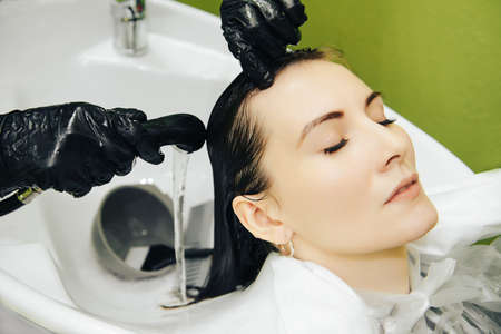 A young girl on cosmetic procedures in a beauty salon, coloring and vitamin complex for hair.の写真素材