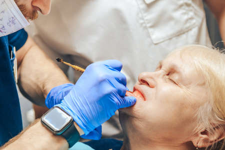 Prosthetics of the removable jaw of an elderly woman. Close-up of the doctor trying on a sample.の写真素材